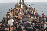 Migrants wait to be be rescued by Acehnese fishermen on their boat on the sea off East Aceh, Indonesia, Wednesday, May 20, 2015. Indonesia and Malaysia agreed Wednesday to provide temporary shelter to thousands of migrants believed to be stranded at sea.