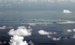 This areal photo taken through a glass window of a military plane shows China's alleged on-going reclamation of Mischief Reef in the Spratly Islands in the South China Sea Monday, May 11, 2015.