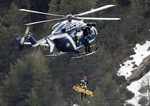 In this Thursday March 26, 2015 file photo a rescue worker is lifted into a helicopter at the crash site near near Seyne-les-Alpes, France.