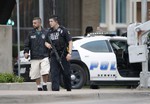 Dallas police officers walk down Belleview Street one block away from police headquarters searching the area Saturday June 13, 2015, in Dallas.