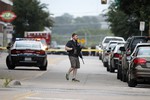 A Dallas police officer walks down Belleview Street one block away from police headquarters searching the area Saturday, June 13, 2015, in Dallas.