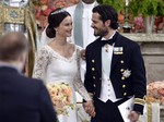 Sweden's Prince Carl Philip, right, stands with his bride, Sofia Hellqvist during their wedding ceremony, in Stockholm, Sweden, Saturday, June 13, 2015.