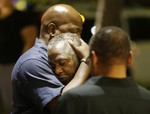 Worshippers embrace following a group prayer across the street from the scene of a shooting at Emanuel AME Church, Wednesday, June 17, 2015, in Charleston, S.C.