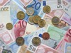 Euro currency coins and banknotes of various denominations.