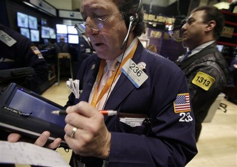 Trader Steven Kaplan, left, works on the floor of the New York Stock Exchange Wednesday, April 28, 2010