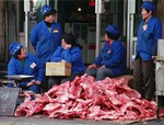 File photo: Chinese store assistants chat as they mind a pile of ribs on sale on the sidewalk outside their store in Beijing. The frozen ribs, thinly covered with meat and mainly used for soup