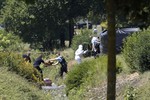 Investigating police officers work outside the plant where an attack took place, Friday, June 26, 2015 in Saint-Quentin-Fallavier, southeast of Lyon, France.