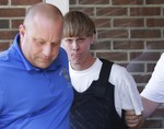 Charleston, S.C., shooting suspect Dylann Storm Roof, center, is escorted from the Sheby Police Department in Shelby, N.C., Thursday, June 18, 2015.