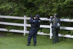 A New York State Department of Corrections Officer, left, and a forest ranger search an area in Owls Head, N.Y. for convicted murderers Richard Matt and David Sweat, Friday, June 26, 2015.