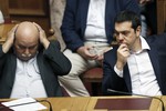 Greece's Prime Minister Alexis Tsipras, right, and Greek Minister of Interior and Administrative Reconstruction Nikos Voutsis attend an emergency Parliament session for the government’s proposed referendum in Athens on Saturday, June 27, 2015.