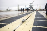 Sailors from the future USS Gerald R. Ford (CVN 78) walk the ship's flight deck following the first "dead-load" test of the ship's  Electromagnetic Aircraft Launch System, Virginia, 5 June, 2015.