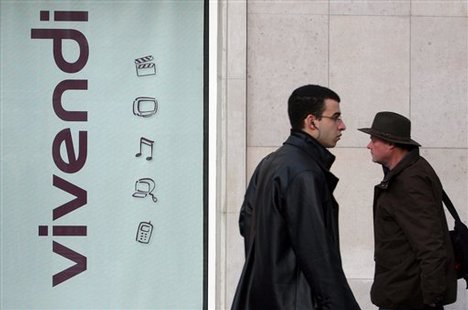 People walk past the headquarters of Vivendi SA in Paris, Monday, Dec. 3, 2007.