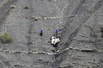 Rescue workers work at the crash site near Seyne-les-Alpes, France, Monday, March 30, 2015. European investigators are focusing on the psychological state of a 27-year-old German co-pilot who prosecutors say deliberately flew a Germanwings plane carrying 150 people into a mountain.