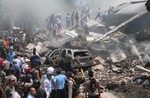 Firefighters and military personnel inspect the site where an Air Force cargo plane crashed in Medan, North Sumatra, Indonesia, tuesday, June 30, 2015.