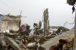 File - Palestinian children, whose houses were destroyed by what they said was Israeli shelling during a 50- day-war last summer, play outside a container used as temporary replacement shelter for their damaged homes, on a stormy day in the east of Khan Younis in the southern Gaza Strip, January 8, 2015.