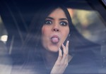 Miss Universe Paulina Vega, from Colombia, jokingly sticks her tongue out at photographers from a car after visiting patients at a military hospital in Bogota, Colombia, Tuesday, April 28, 2015.