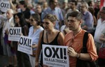 People hold banners reading, ""No to the Troika, I support Greece" during a pro Greece demonstration at the European Union office in Barcelona, Spain, Friday, July 3, 2015 .