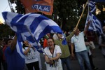 A supporter of the No vote waves a Greek flag after the referendum's exit polls at Syntagma square in Athens, Sunday, July 5, 2015.