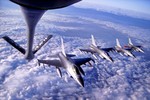 A 100th Air Refueling Wing KC-135 Stratotanker prepares to offload fuel to Royal Danish Air Force F-16 Fighting Falcons, which are flying in formation behind the tanker. The 100th ARW arrived at Royal Air Force Mildenhall Feb. 1, 1992 and has supported U.S. and partner nation military aircraft over a span of more than 20 million square miles using its 15 assigned KC-135s.