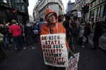 File - A protester, name not given, demonstrates against rising energy prices outside the headquarters of energy provider Npower in London's City financial district, Tuesday, Nov. 26, 2013.