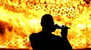 A man playing the flute as the Ballymacash bonfire burns in Lisburn. William Cherry/Presseye.