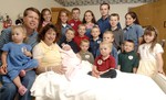 In this Aug. 2, 2007 file photo, Michelle Duggar, left, is surrounded by her children and husband Jim Bob, second from left, after the birth of her 17th child in Rogers, Ark.