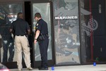 Police officers enter the Armed Forces Career Center through a bullet-riddled door after a gunman opened fire on the building Thursday, July 16, 2015, in Chattanooga, Tenn.