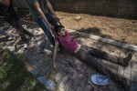 A man pulls a youth just after an explosion that killed dozens of people and injured scores of others, rocked the Turkish town of Suruc near the Syrian border, Monday, July 20, 2015.