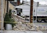 A garbage truck moves past rubble in front of the earthquake damaged Vintners Collective multi-winery tasting room Monday, Aug. 25, 2014, in Napa, Calif.