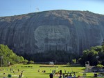 Detail of the mountain and carving with park visitors. At Stone Mountain, Georgia, United States.