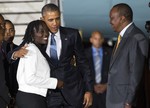 Kenyan President Uhuru Kenyatta, right, watches as President Barack Obama, center, hugs his half-sister Auma Obama, after he arrived at Kenyatta International Airport, on Friday, July 24, 2015, in Nairobi, Kenya. Obama is traveling on a two-nation African tour where he will become the the first sitting U.S. president to visit Kenya and Ethiopia.