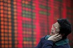 File: An investor looks at the stock price monitor at a private securities company in Shanghai, China.