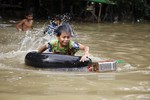 A boy rides inner tube as he swims in a flooded road in Bago, 80 kilometers (50 miles) northeast of Yangon, Myanmar, Saturday, Aug 1, 2015.