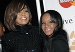 In this Feb. 12, 2011, file photo, singer Whitney Houston, left, and daughter Bobbi Kristina Brown arrive at an event in Beverly Hills, Calif.