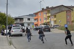 Turkish police officers run for cover during a gunfight near the site of an overnight explosion at a police station in Istanbul's Sultanbeyli neighborhood, Monday, Aug. 10, 2015.