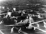 File - Pearl Harbor Attack, 7 December 1941. Japanese naval aircraft prepare to take off from an aircraft carrier (reportedly Shokaku) to attack Pearl Harbor during the morning of 7 December 1941. Plane in the foreground is a "Zero" Fighter, in front of "Val" dive bombers.