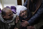 A man is comforted by others as he mourns over Egyptian Coptic Christians who were captured in Libya and killed by militants affiliated with the Islamic State group, outside of the Virgin Mary church in the village of el-Aour, near Minya, 220 kilometers (135 miles) south of Cairo, Egypt, Monday, Feb. 16, 2015.