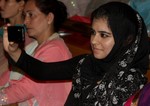 A Kashmiri Girl talk picture with mobile phone Students of Mallinson Girls School Srinagar present a cultural item during the centenary celebrations of the School at Skicc Srinagar on 31, August 2012.