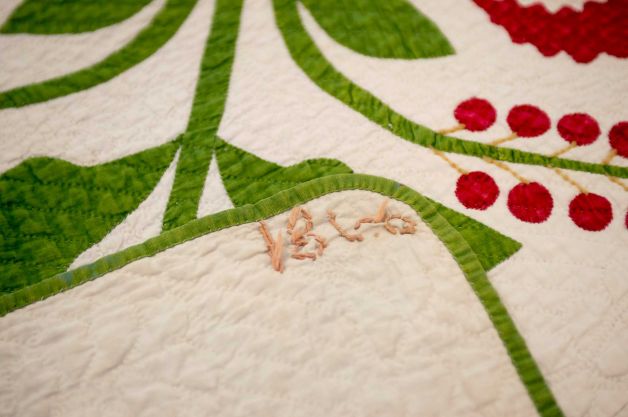 ADVANCE FOR THE WEEKEND OF JULY 18-19 AND THEREAFTER - In a July 10, 2015 photo, the year 1860 is stitched on the family's cherry quilt. The quilt was donated to the International Quilt Study Center and Museum in Lincoln, Neb., by the family. Made in 1860, it was passed down through the family and occasionally squabbled over. (Matt Ryerson/Lincoln Journal Star via AP) Photo: Matt Ryerson, AP / Lincoln Journal Star