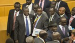 South Sudan's rebel leader Riek Machar, second left, looks across after shaking hands with South Sudan's President Salva Kiir, center-right wearing a black hat, after lengthy peace negotiations in Addis Ababa, Ethiopia Monday, Aug. 17, 2015.