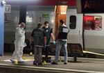 Police officers work on a platform next to a Thalys train at Arras train station, northern France, Friday, Aug. 21, 2015. A gunman opened fire with an automatic weapon on a high-speed train traveling from Amsterdam to Paris Friday, wounding three people before being subdued by two American passengers