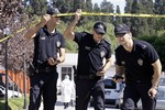 Police officers secure the area around the scene of three explosions, as forensic officers examine the site, at the Uskudar district Parks Department in Istanbul, Turkey, Thursday, Aug. 7, 2008. The explosions occurred near the municipal building in Istanbul on Thursday, slightly injuring three people, an official and Turkish news reports