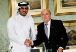 In this Saturday, Nov. 9, 2013, file photo, FIFA President Sepp Blatter, right, shakes hands with Sheik Mohammed bin Hamad al-Thani, chairman of Qatar 2022 bid committee, at a press conference in Doha, Qatar.