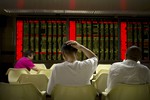 Investors monitor displays of stock information at a brokerage house in Beijing, Wednesday, July 15, 2015. Shanghai stocks lost ground on Wednesday despite China's better-than-expected economic growth in the second quarter, with investors still wary after a big slide in Chinese markets. (AP Photo/Mark Schiefelbein)