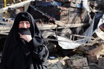 An Iraqi woman grieves at the scene of a bomb attack in Jameela market in the Iraqi capital's crowded Sadr City neighborhood Baghdad, Iraq, Thursday, Aug. 13, 2015.