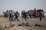 Palestinians run for cover from tear gas fired by Israeli security forces during clashes that occurred after the funeral of Palestinian Saed Dawabsheh, 32, in the West Bank village of Duma near Nablus on Saturday, Aug. 8, 2015.