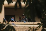 Thai policemen stand outside the suspect's room at an apartment on the outskirts of Bangkok, Thailand on Saturday, Aug. 29, 2015.