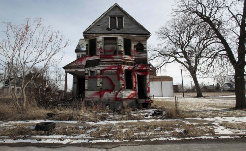 A vacant and blighted home, covered with red spray paint, sits alone in an east side neighborhood once full of homes in Detroit