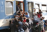 Migrants struggle to board a train at the railway station in Budapest, Hungary, Thursday, Sept. 3, 2015.