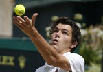 Taylor Fritz of the United States serves to Reilly Opelka of the United States plays a return to during the boys' singles match at the All England Lawn Tennis Championships in Wimbledon, London, Friday July 10, 2015.